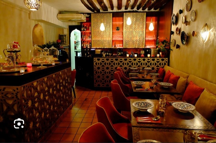 Restaurant décoré avec tables, coussins et éclairages chaleureux