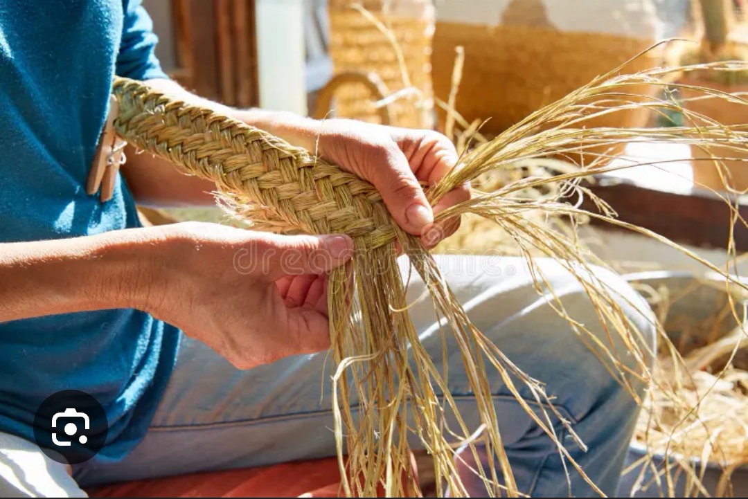 Artisan tressant des fibres naturelles pour créer un objet décoratif