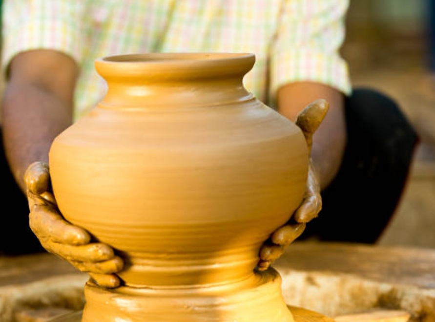 Main d'artisan sculptant une pièce de bois ajourée